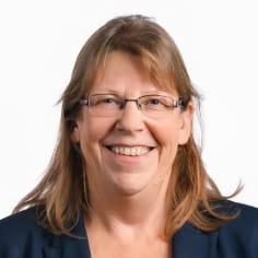 Headshot photo of a woman with glasses and shoulder length brown hair
